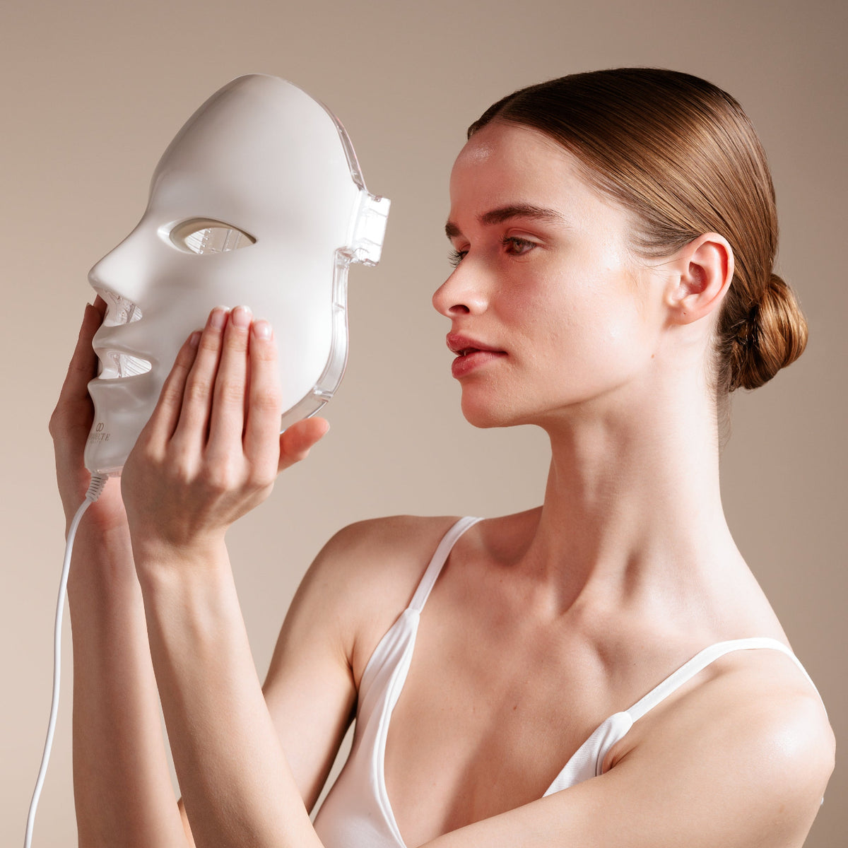 Beauty model showcasing the red light therapy skincare device