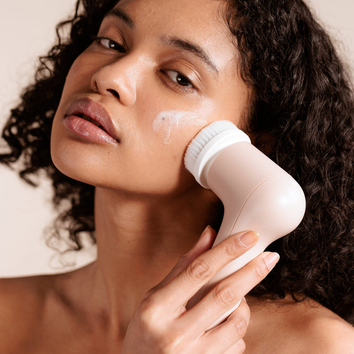 Model demonstrating Gloa electric cleansing brush treatment.