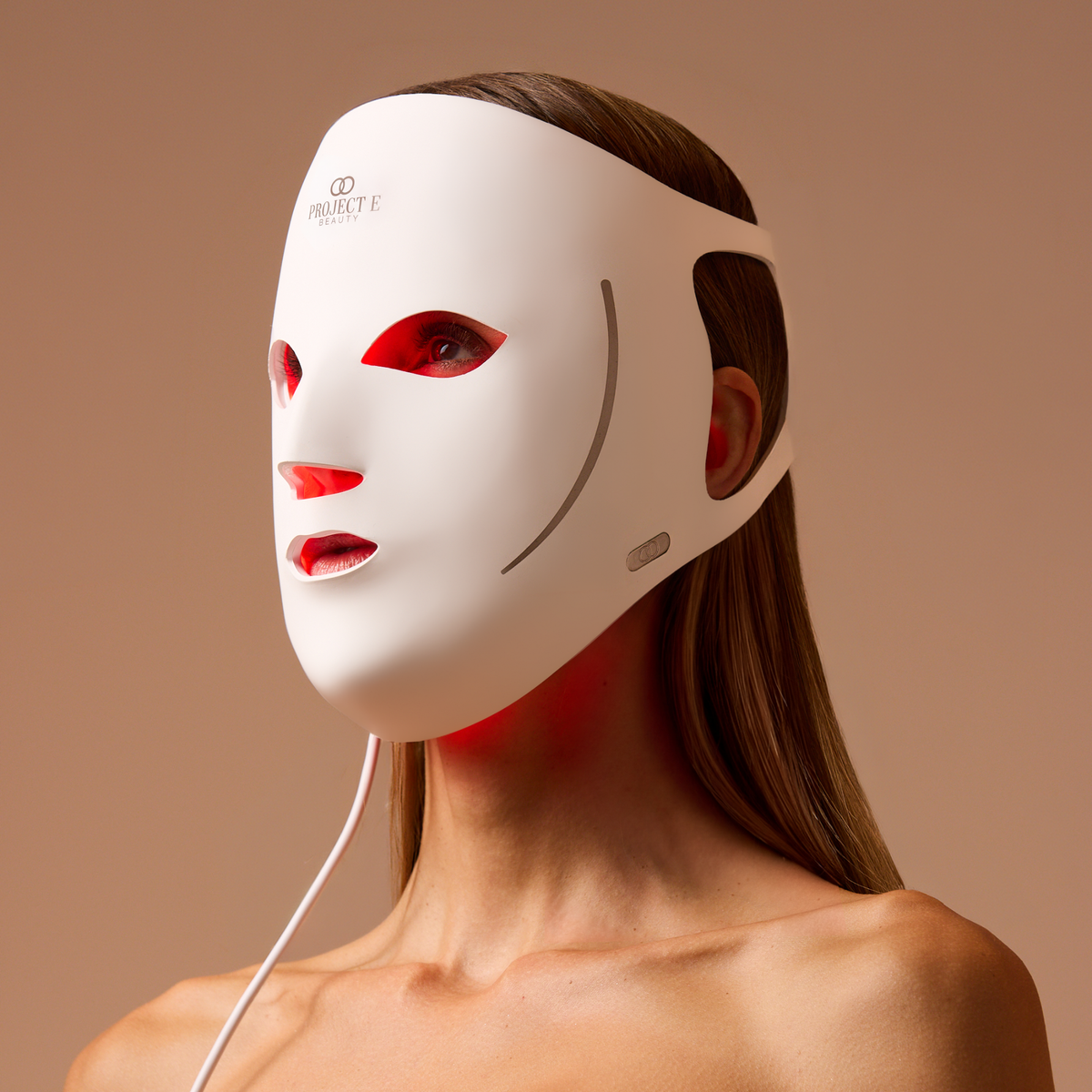 Frau trägt die weiße LumaLux Face V2 Maske mit sichtbarem Rotlicht im Inneren